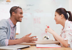 Businessman and businesswoman sitting face to face in meeting